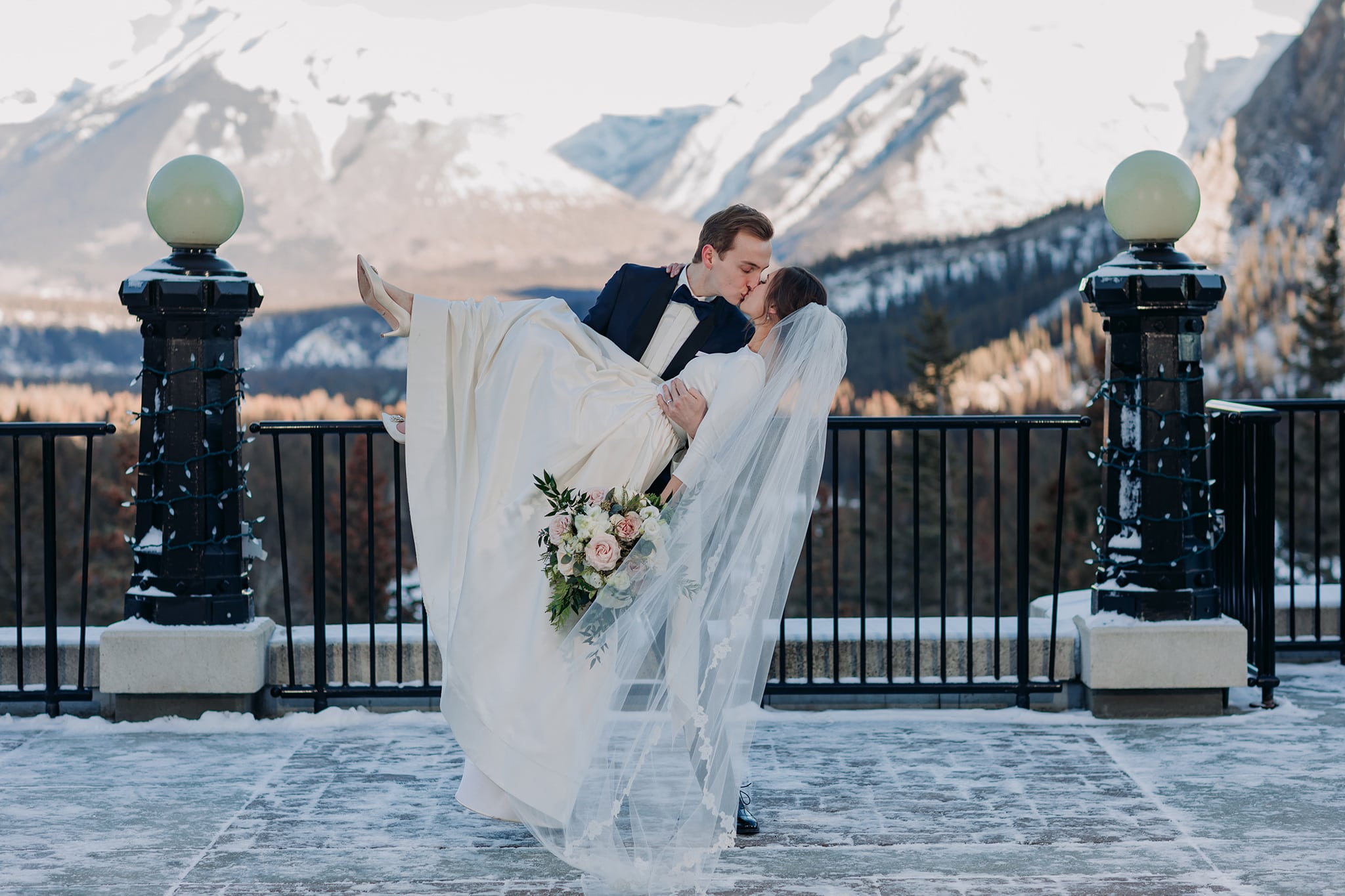 Groom dipping bride on Fairmont Banff SPrings Terrace