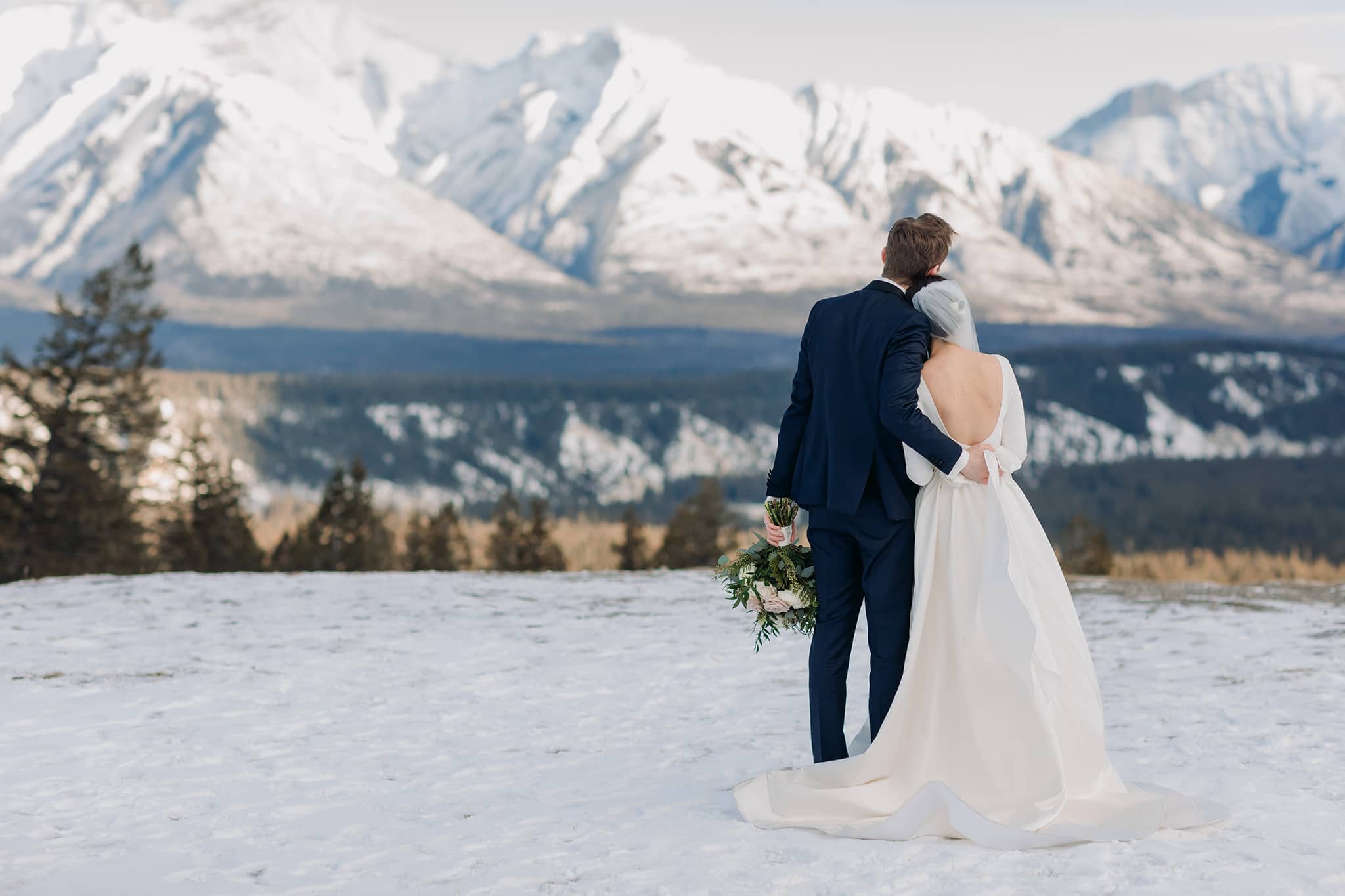bride groom enjoying mountain view overlooking Banff for winter wedding