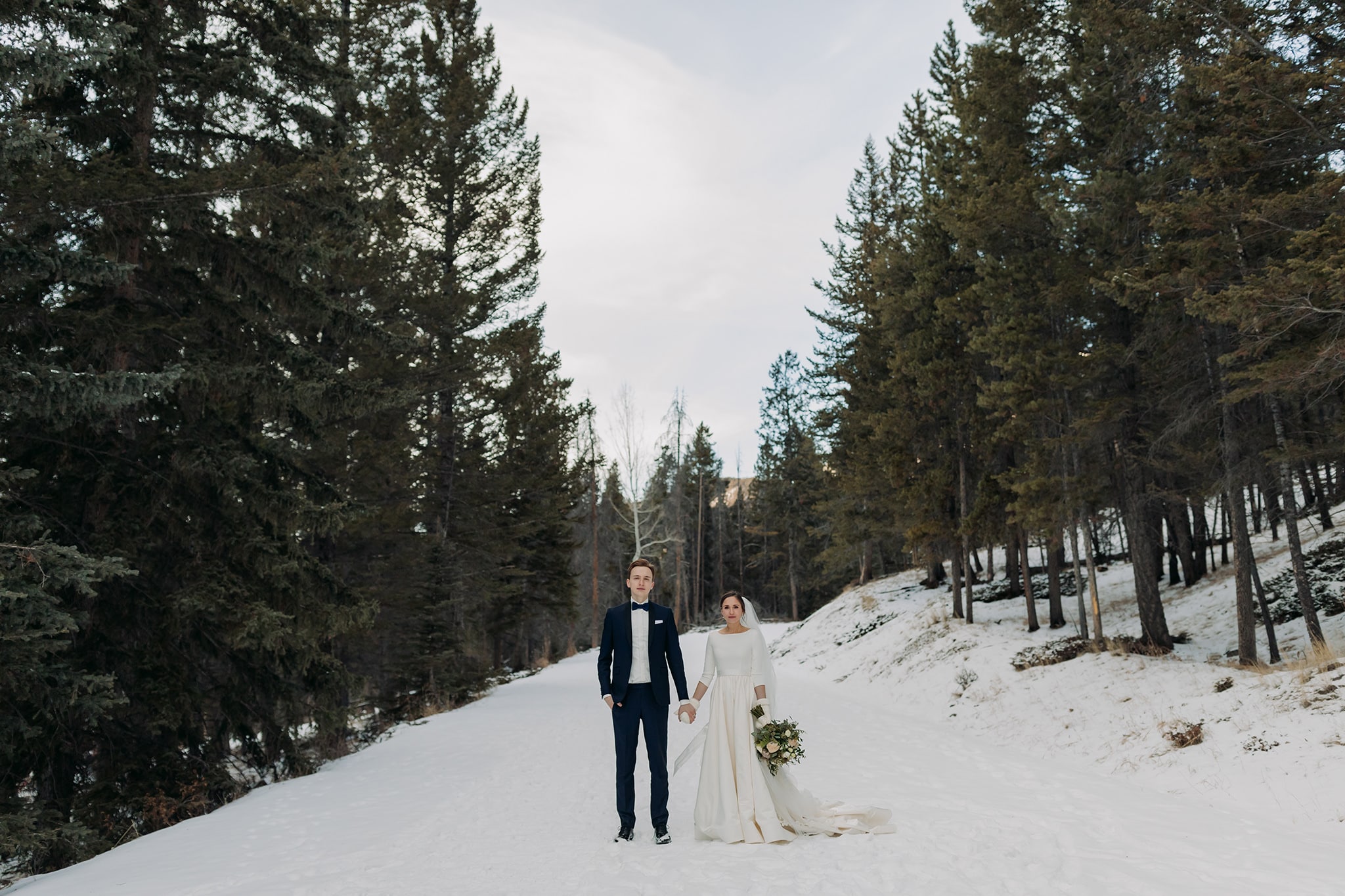 serious wedding portrait in snow road in Banff National Park