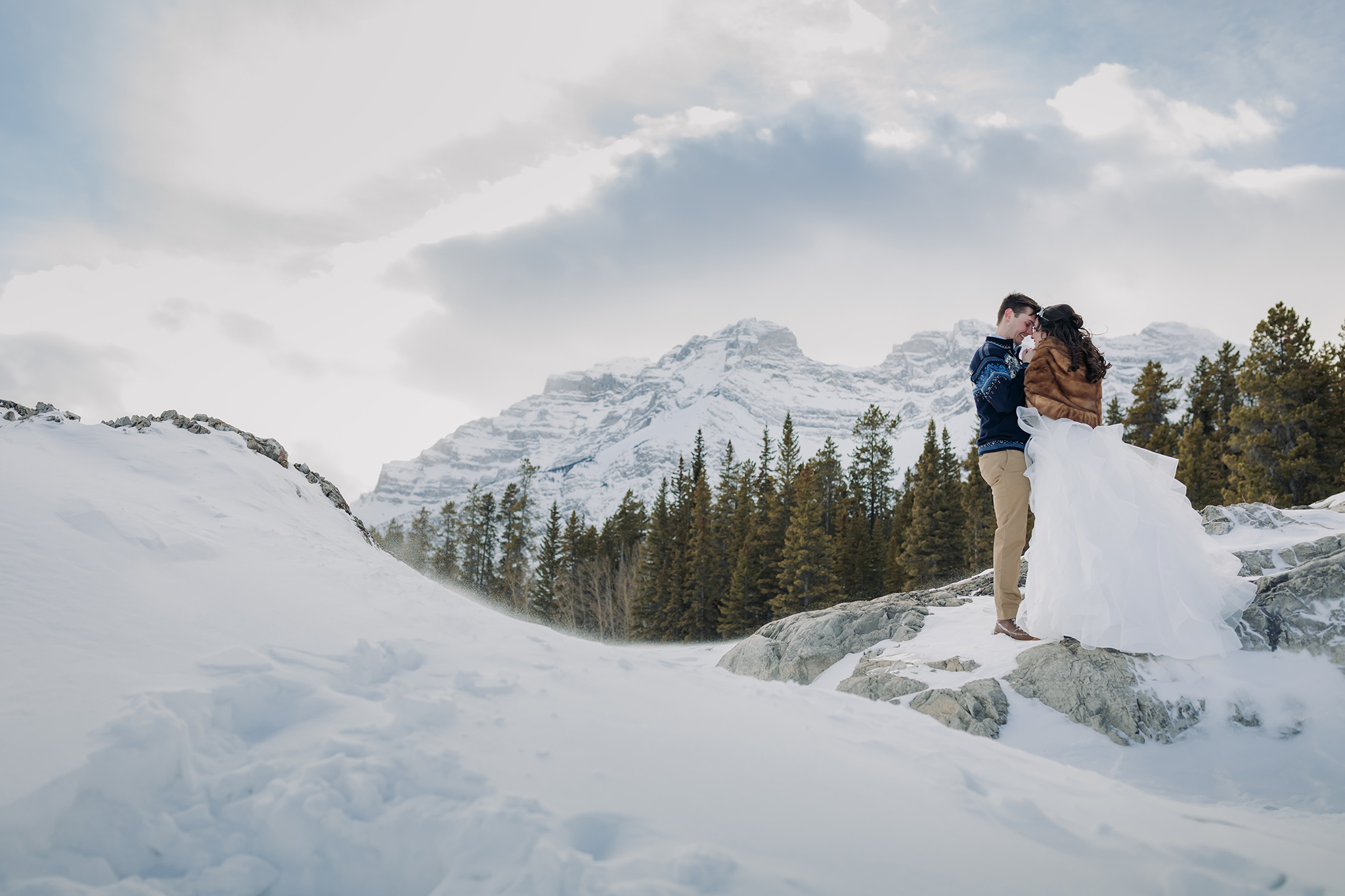 A Guide to Eloping in the Canadian Rockies | Mountain Wedding photographed by ENV Photography | Windy winter wedding at Lake Minnewanka in Banff